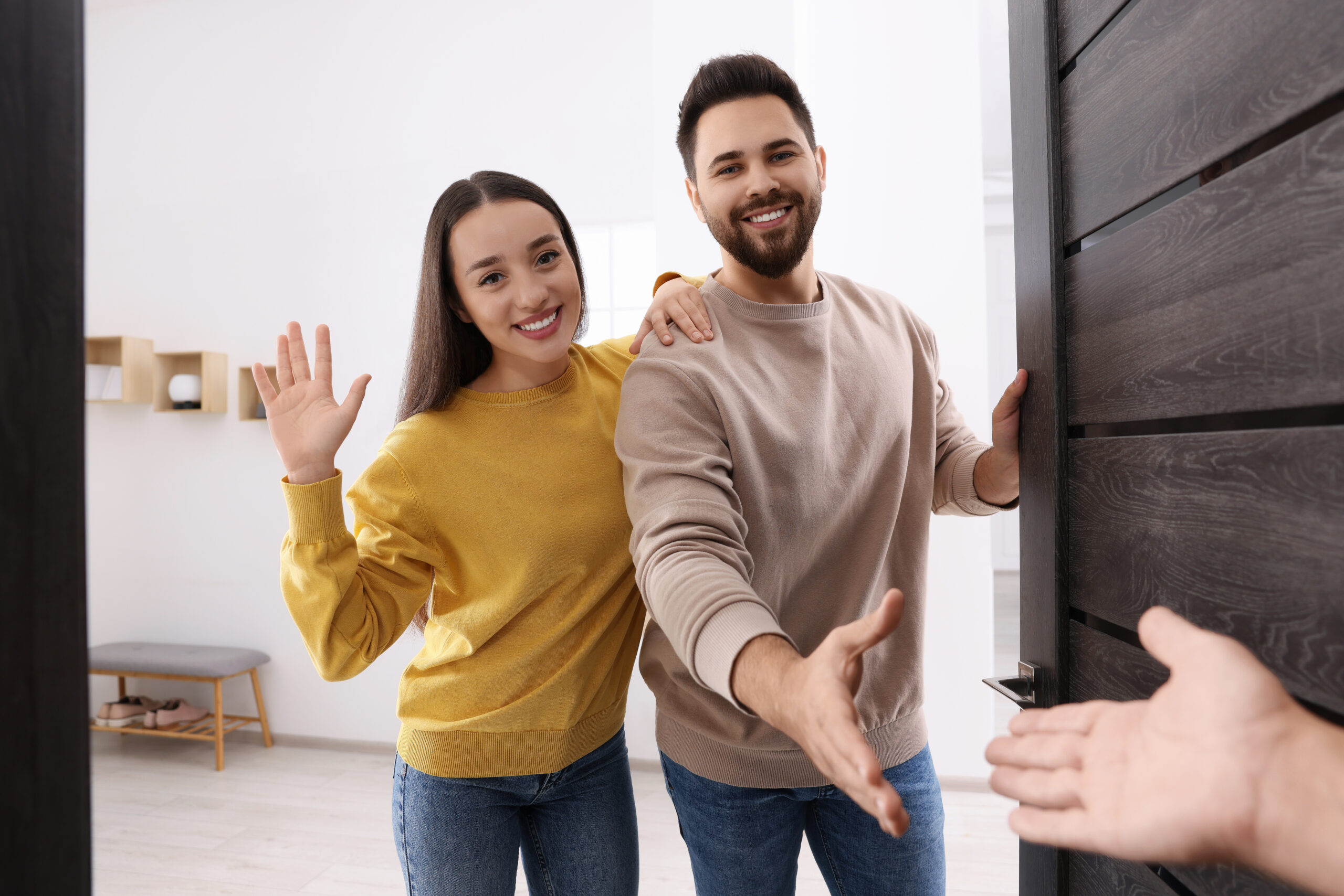 Couple welcoming a visitor at their front door